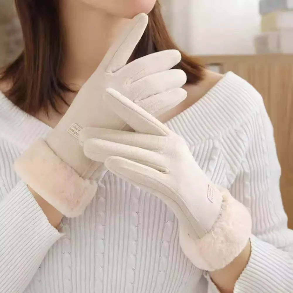 A close-up of a person wearing off-white winter gloves, paired with a white ribbed sweater.