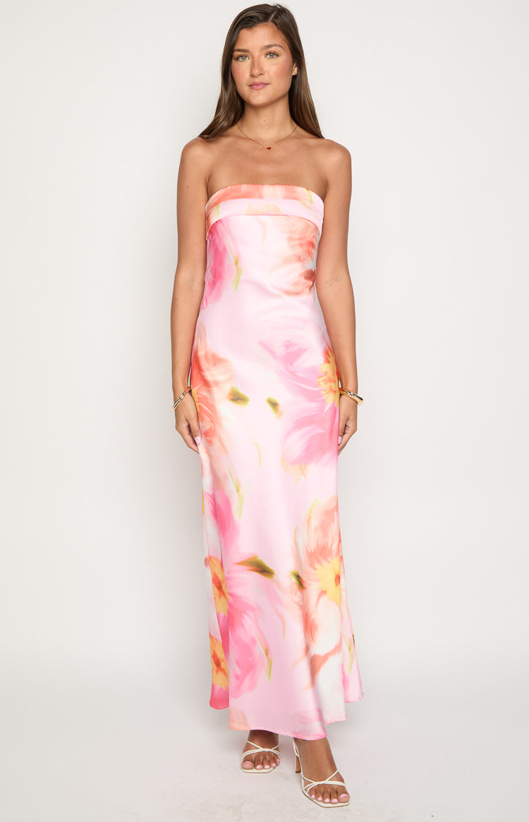 girl wearing a pink strapless occasion maxi dress with an open back and cowl details featuring an oversized floral print