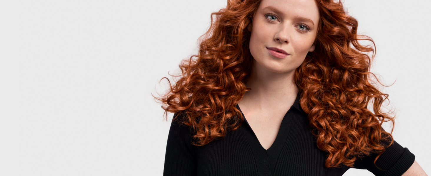 Model with red wavy hair styled into 80&rsquo;s curls