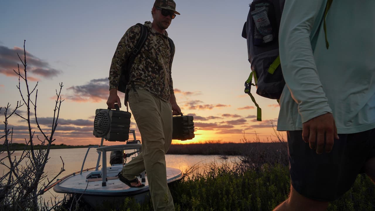 A man carrying two Turtleboxes in his hands.