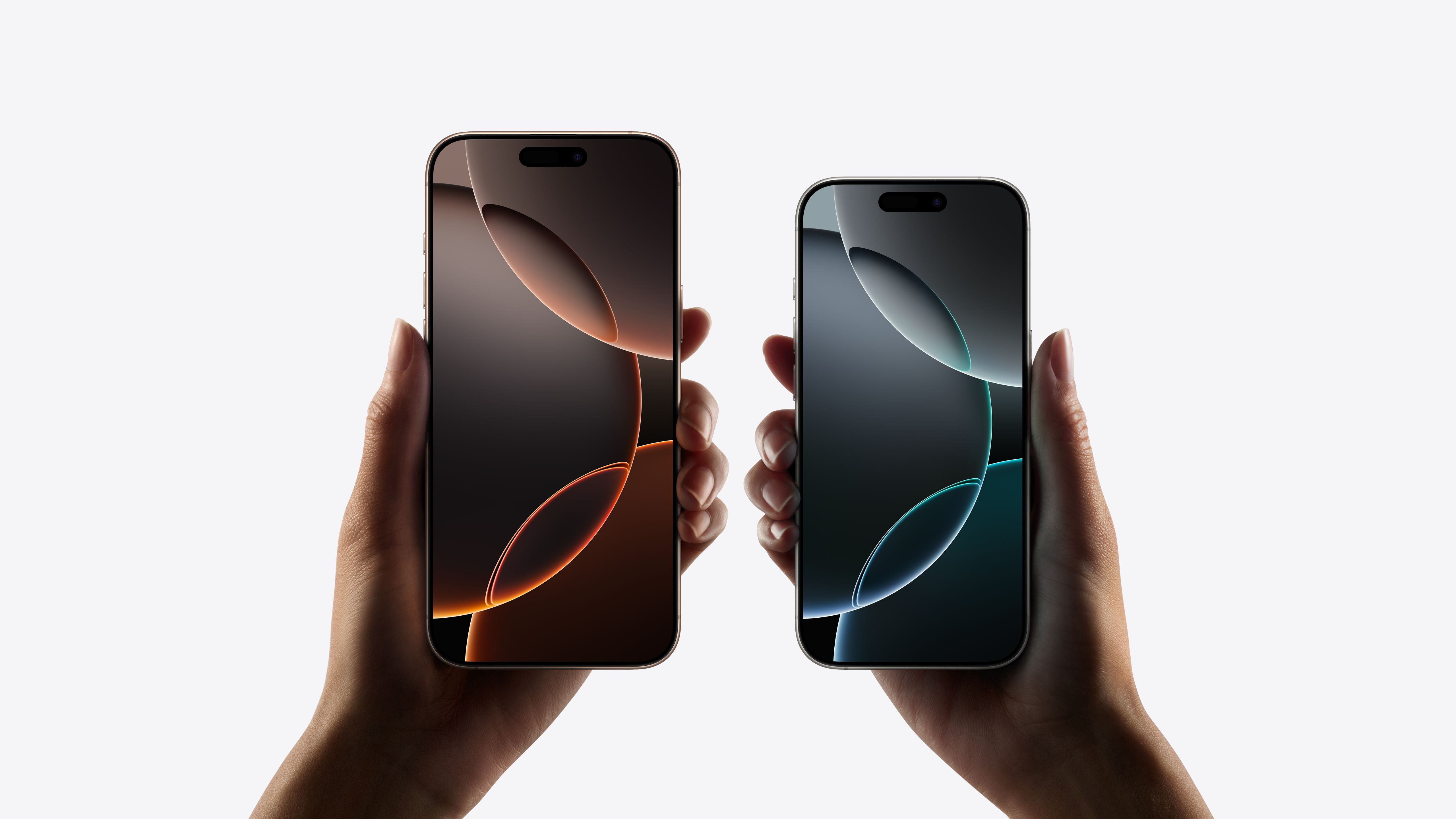 Two models, iPhone 16 Pro Max, iPhone 16 Pro, a hand holds each model, iPhone 16 Pro Max is taller and wider in the hand than iPhone 16 Pro, all screen display, Dynamic Island centred near top, rounded corners.