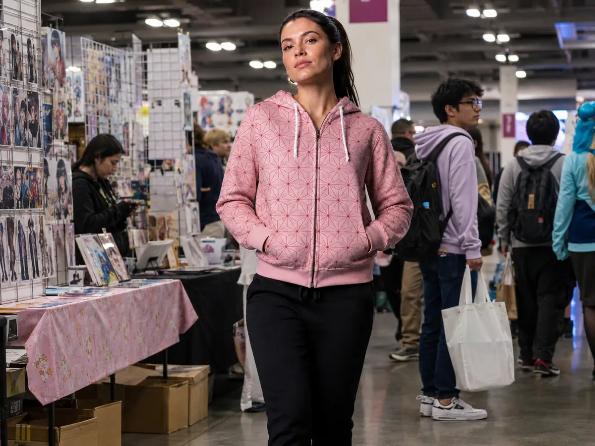 Woman wearing a pink geometric zip hoodie at a convention
