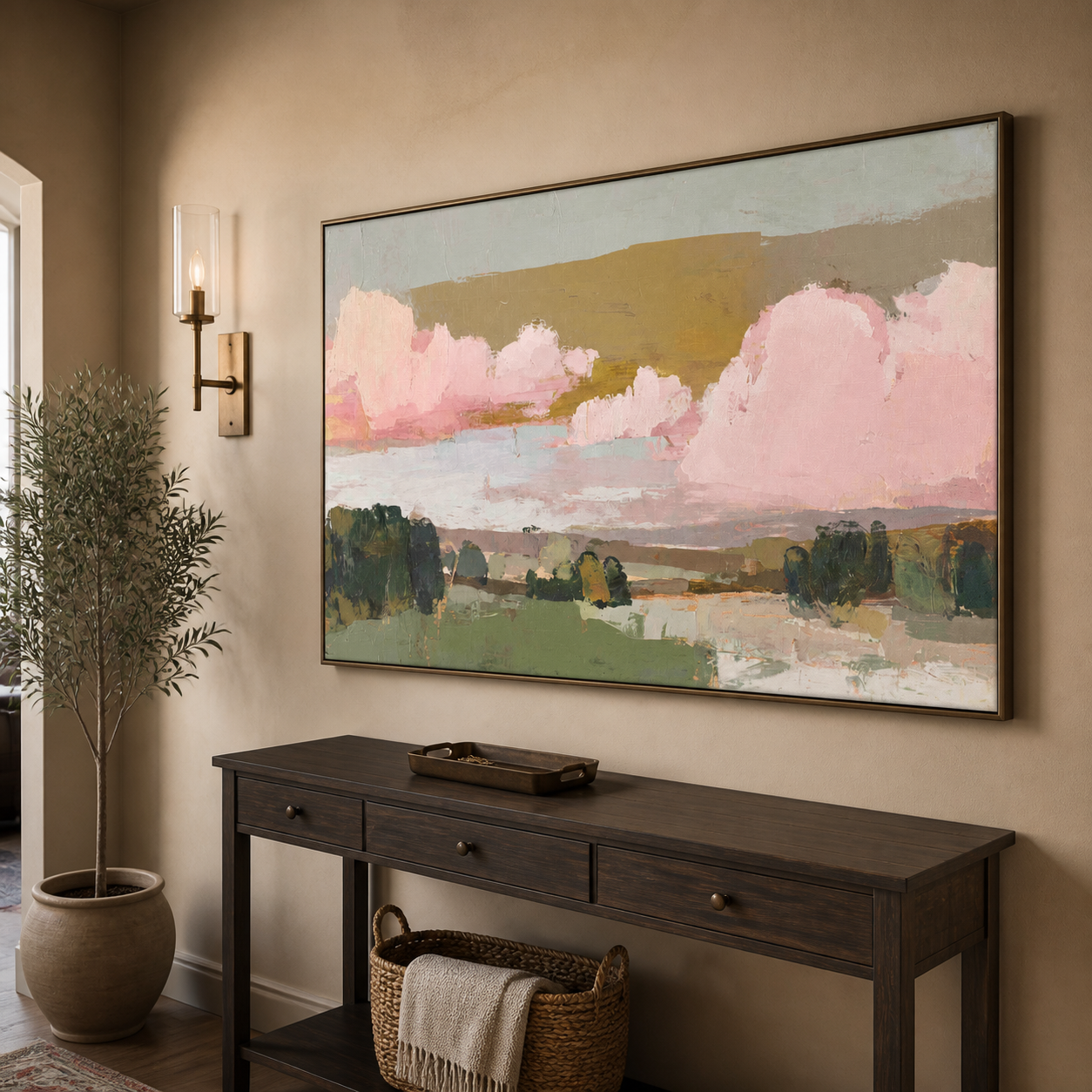 Large pink clouds above green fields and dark trees under a muted ochre sky, shown in a room setting