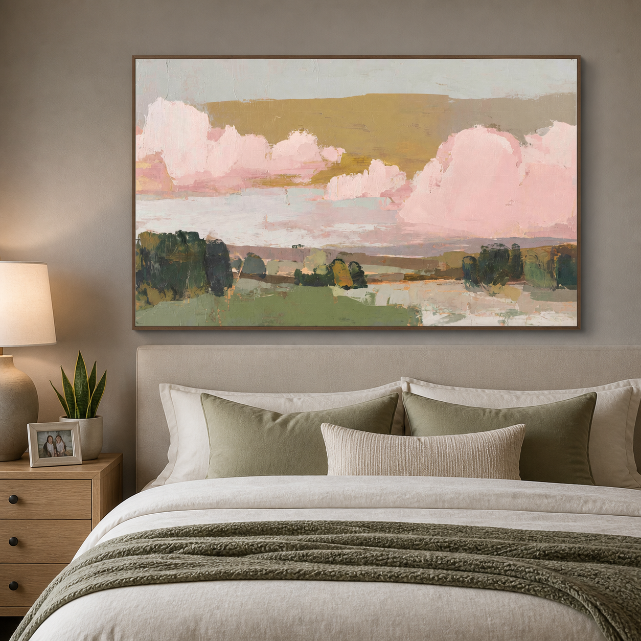 Large pink clouds above green fields and dark trees under a muted ochre sky, shown in a room setting