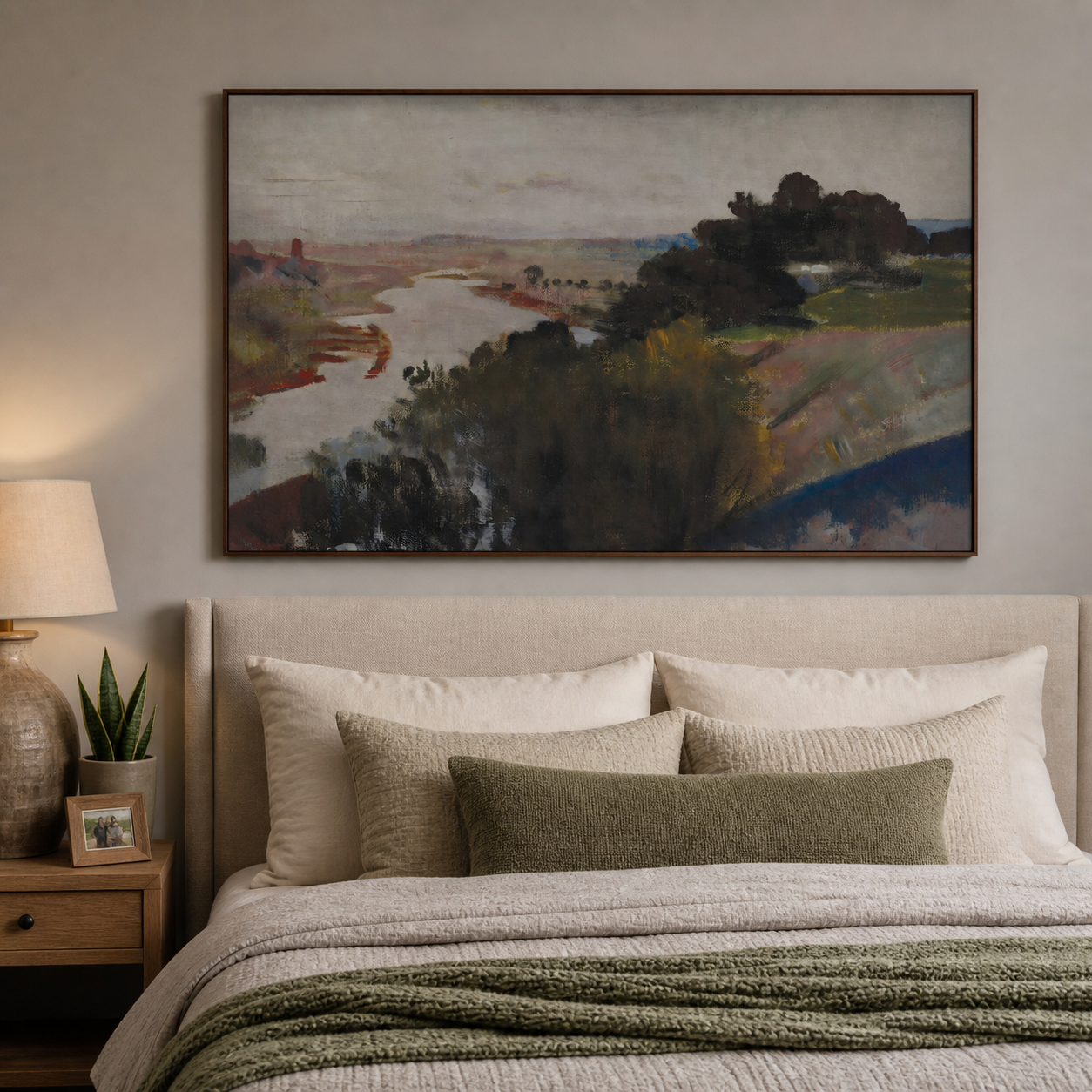 A winding pale river through muted rust and olive countryside with dark trees and a gray sky, shown in a room setting