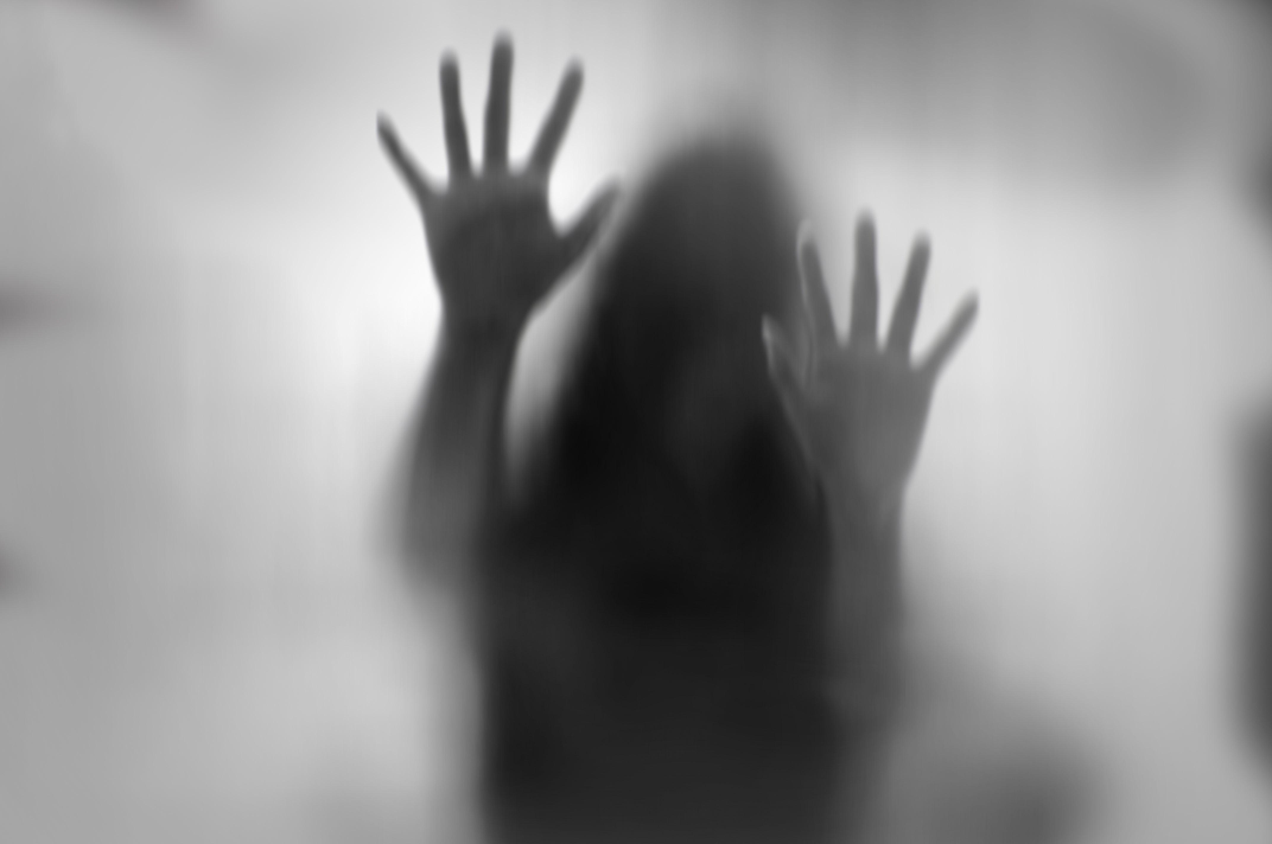Horror woman behind the matte glass in black and white