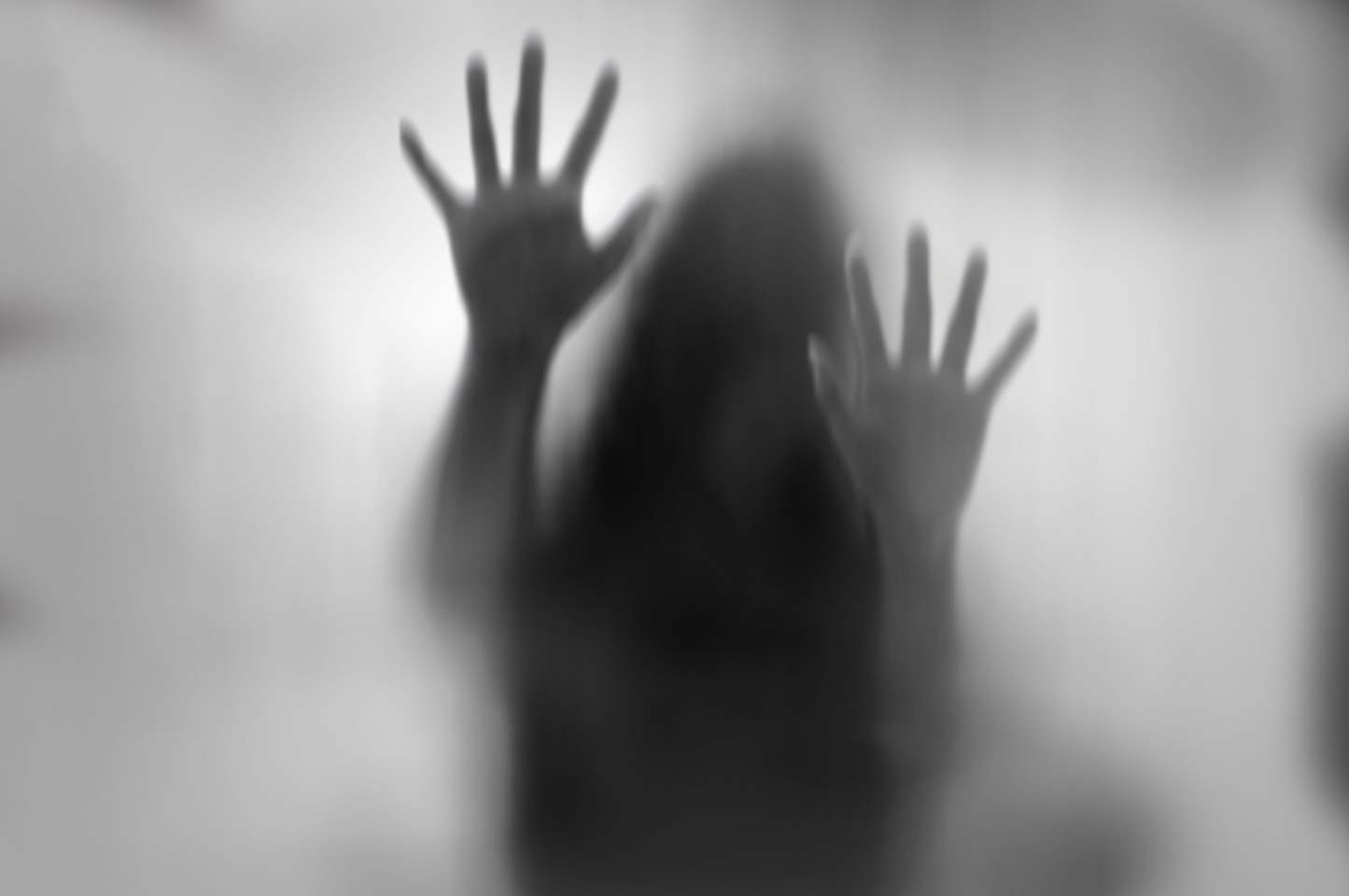 Horror woman behind the matte glass in black and white