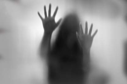 Horror woman behind the matte glass in black and white
