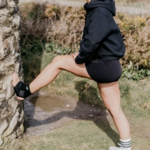 Woman stretching her ankle while wearing BODYPROX Ankle Support Brace