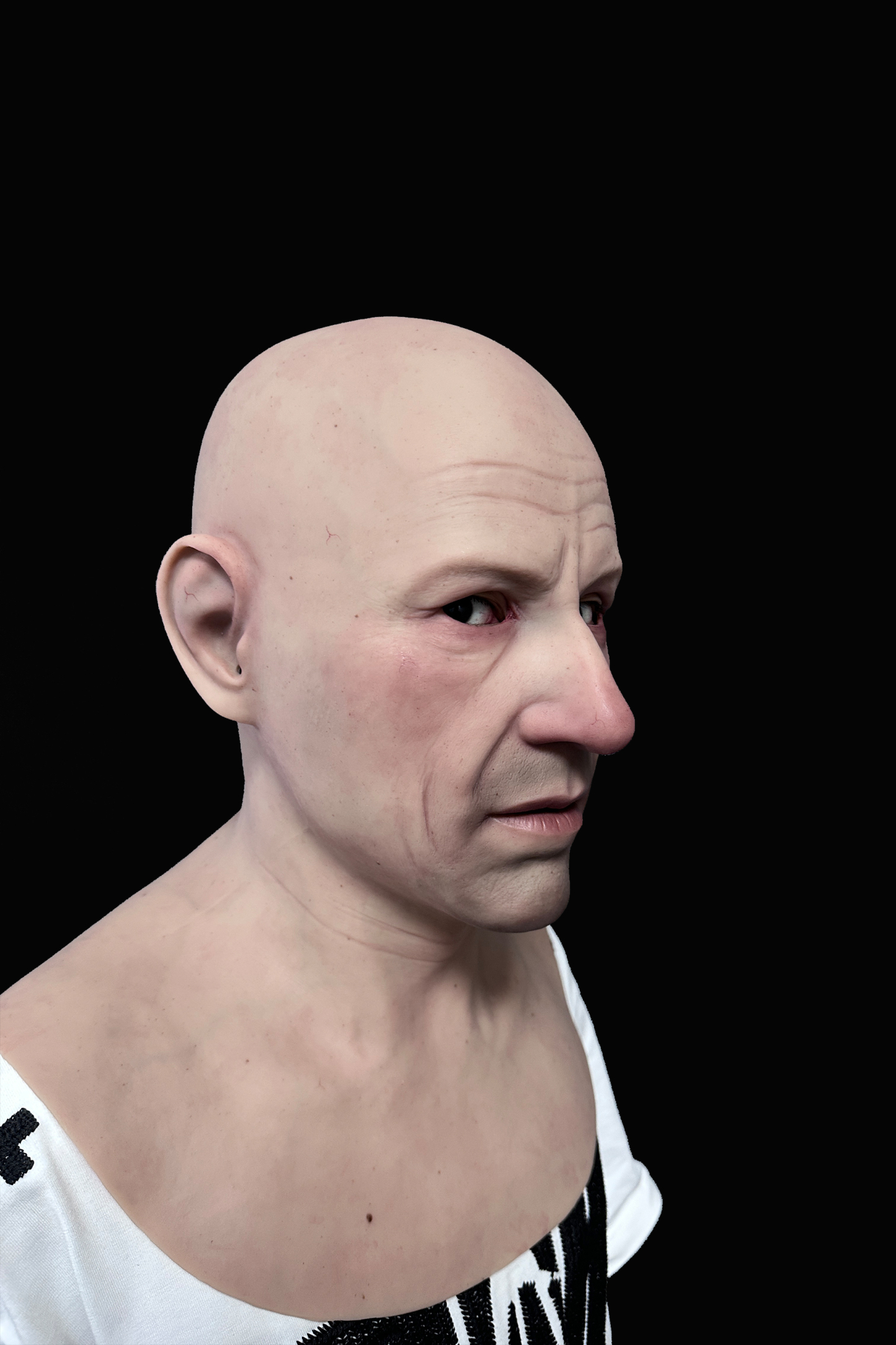 Bald elderly man silicone mask with realistic wrinkles and pale skin tone