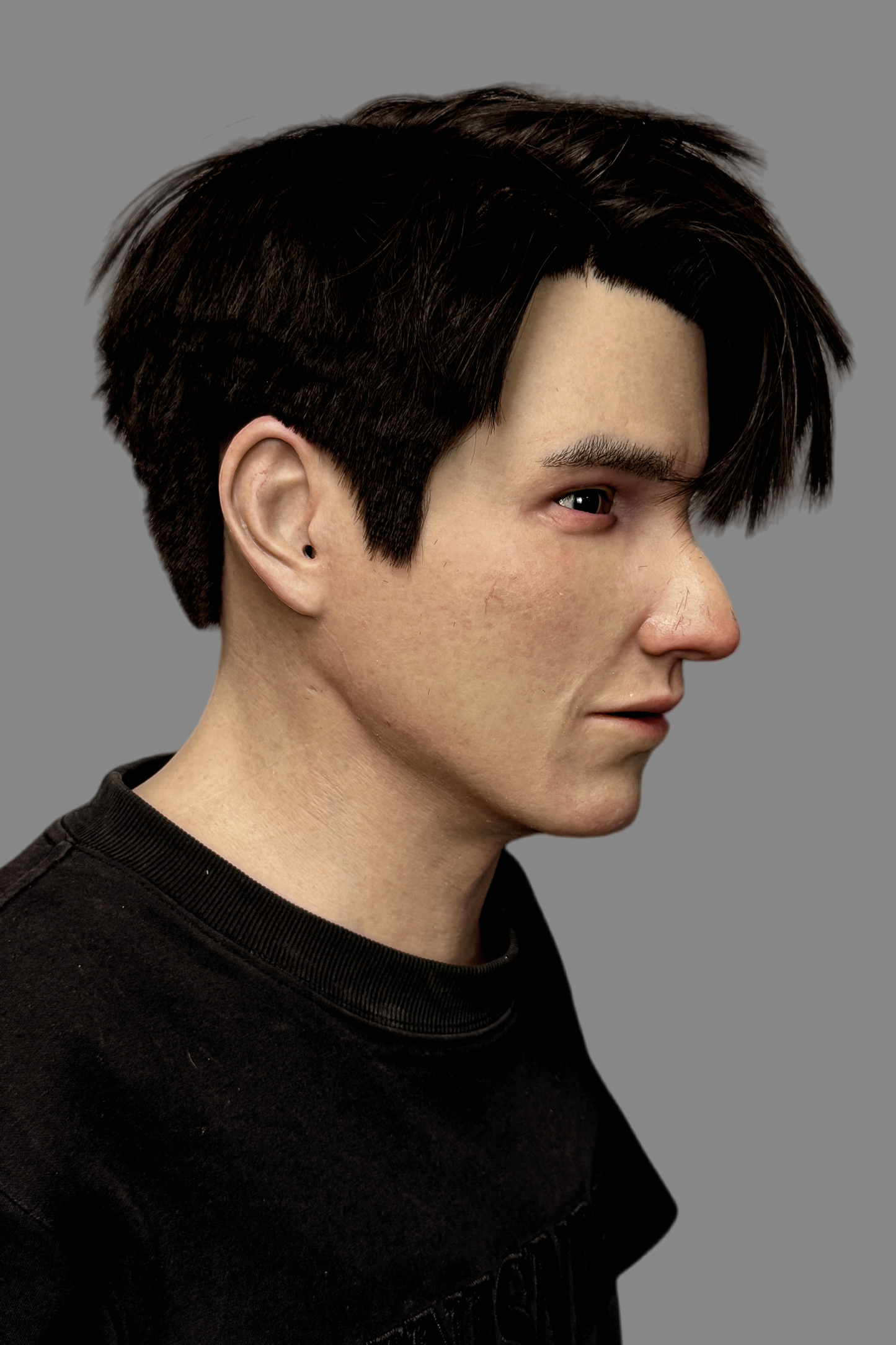 Hyper-realistic young Asian male silicone mask with real human hair worn on model, front view showing natural expression and skin details.