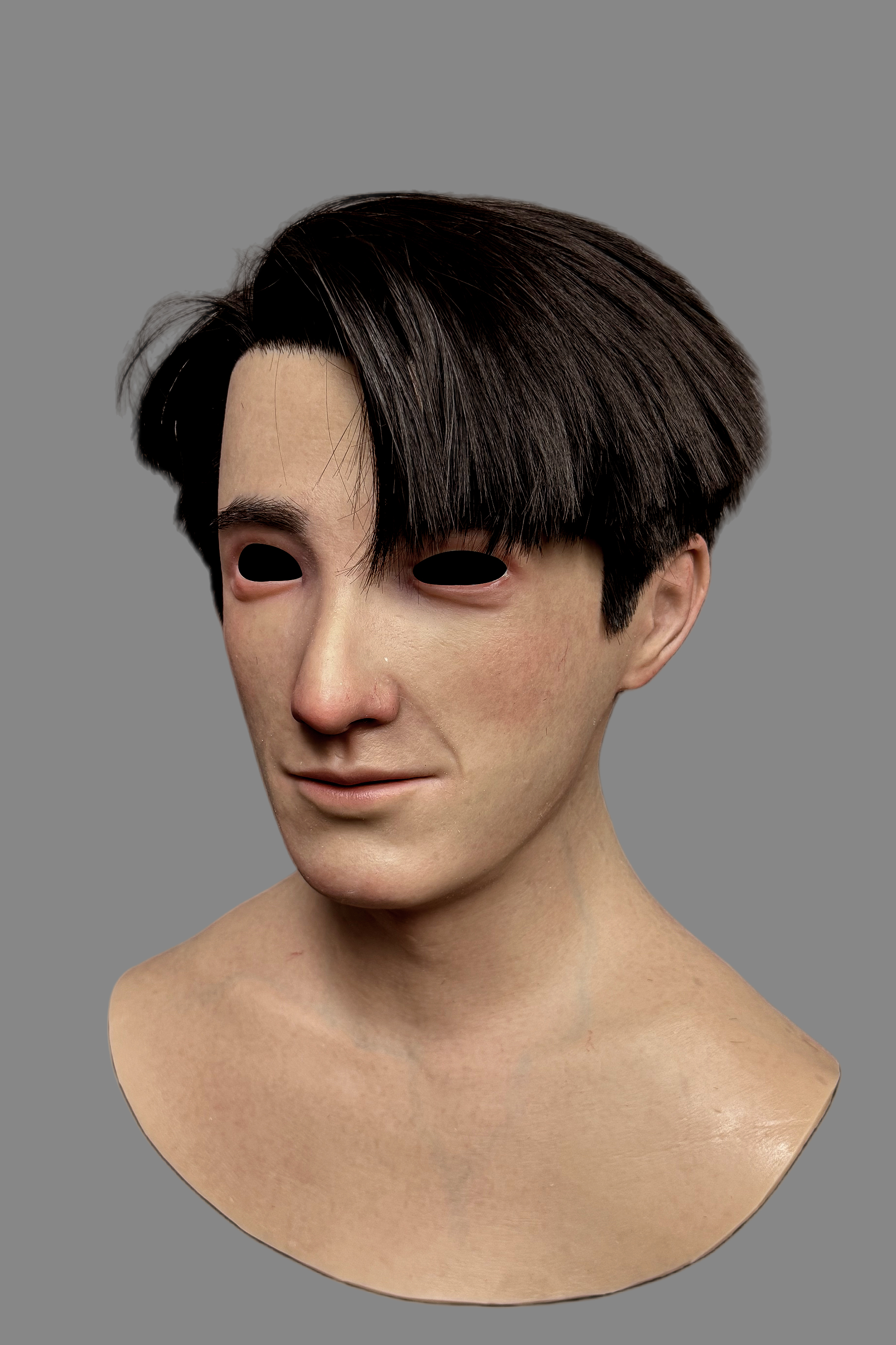 Hyper-realistic young Asian male silicone mask with real black hair, natural skin texture, and subtle pores, front view on model