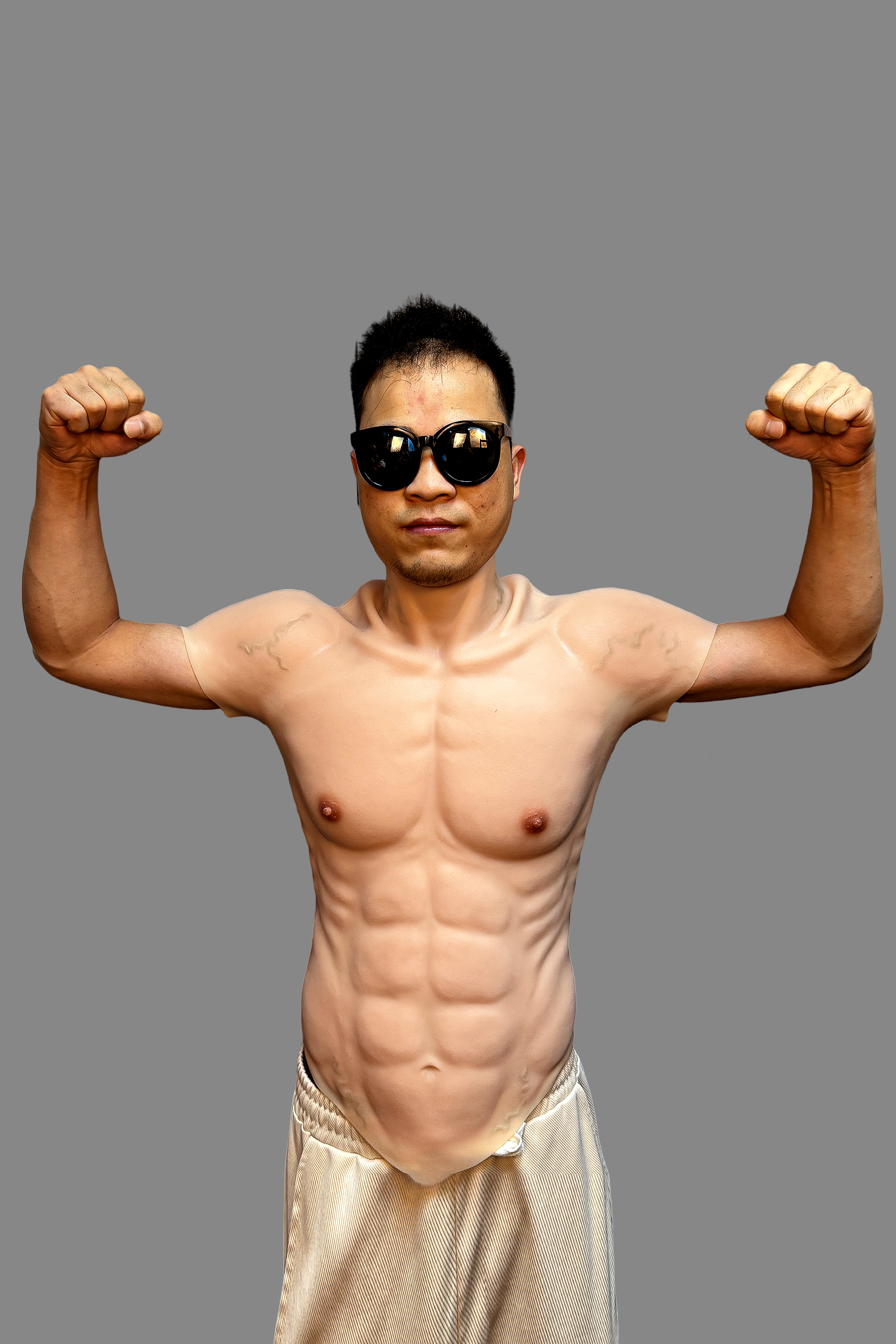 Hyper-realistic fake muscle torso suit featuring 8-pack abs, muscular chest and arms, front view with flexing pose and black sunglasses