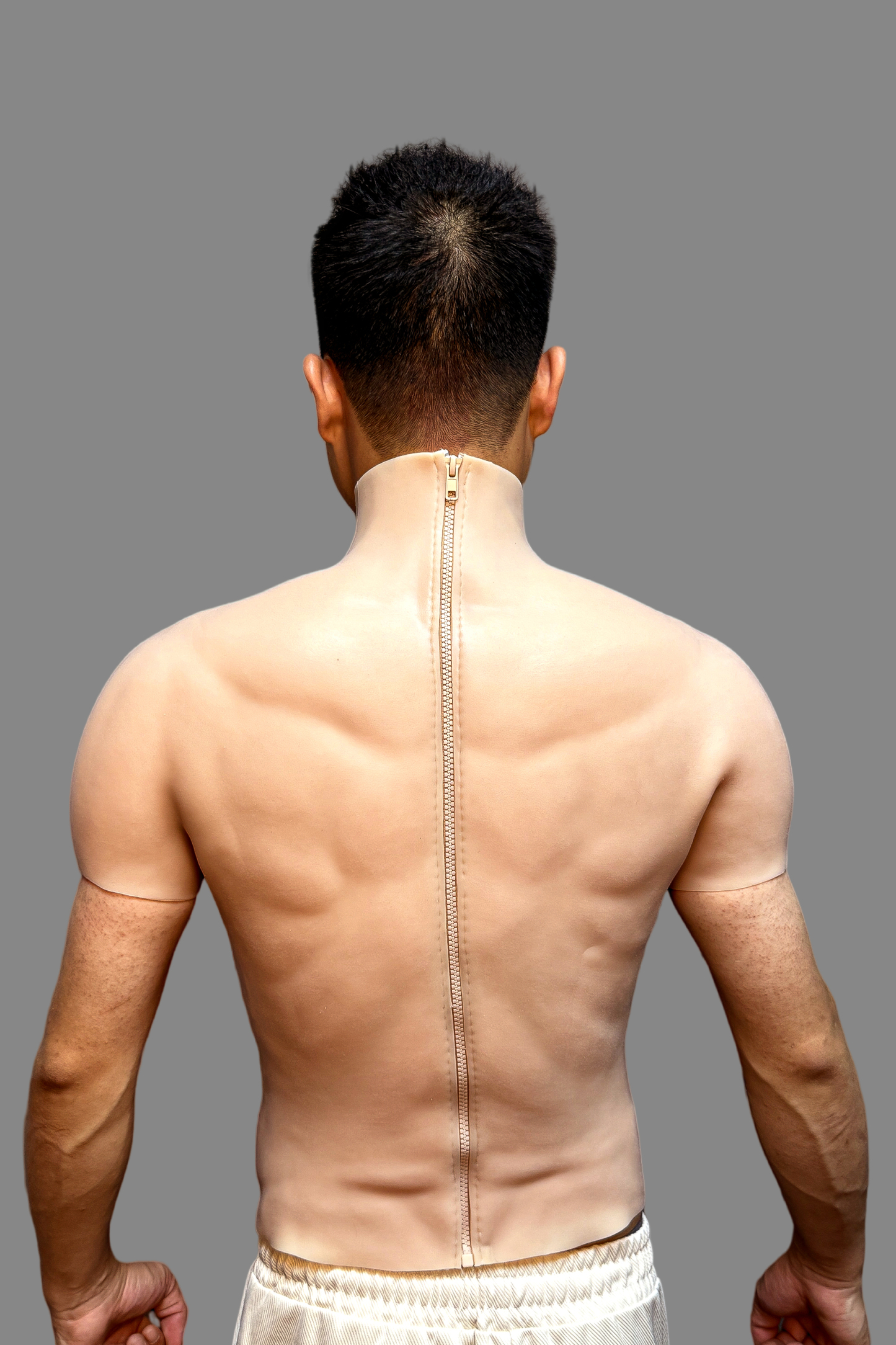 Realistic muscle enhancer silicone vest with defined shoulders, chest and abs, three-quarter view worn with white sport sunglasses.