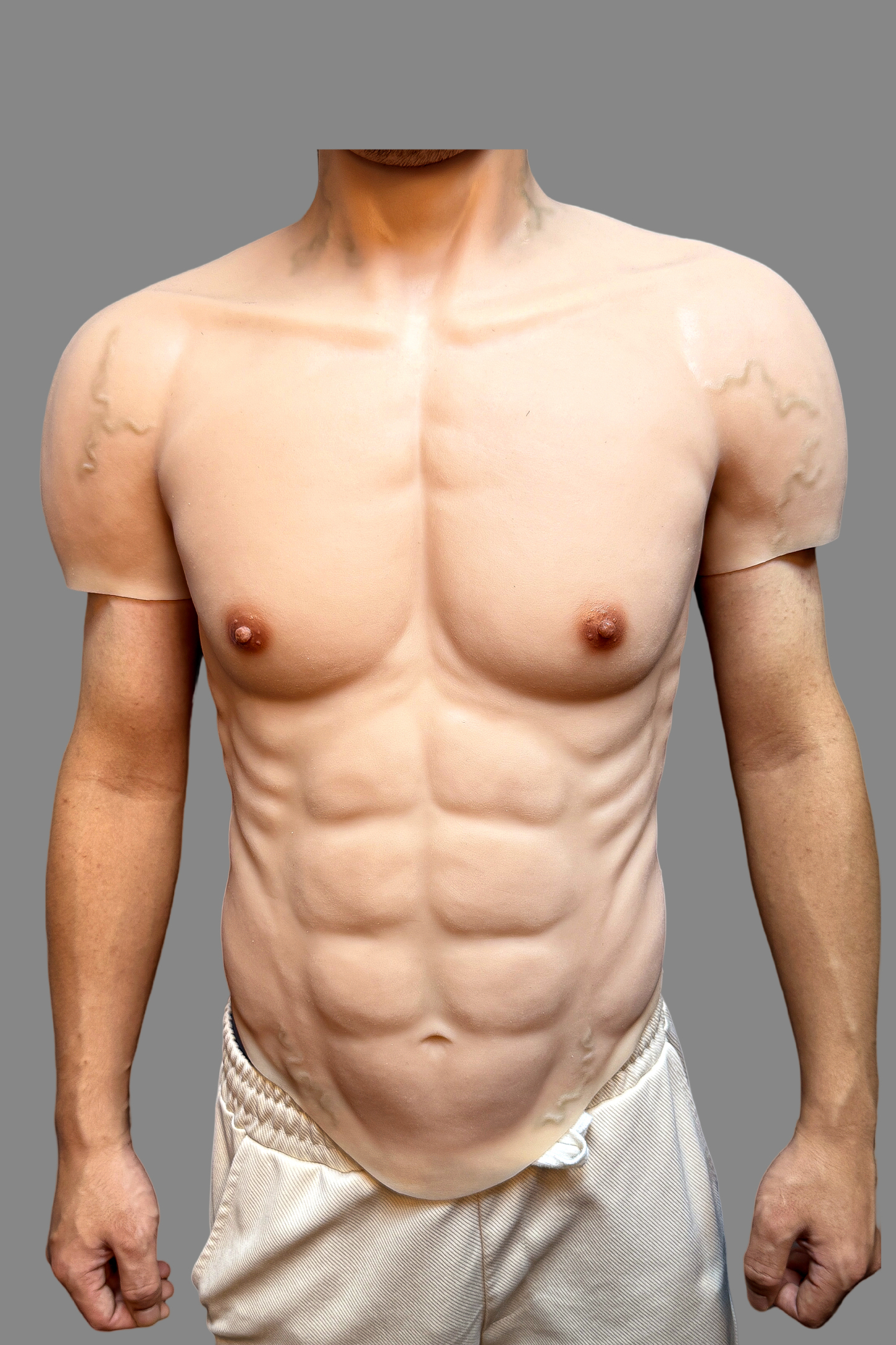 Premium silicone fake muscle suit showing ultra-realistic 8-pack abs, nipples and skin pores, high-definition close-up front view.