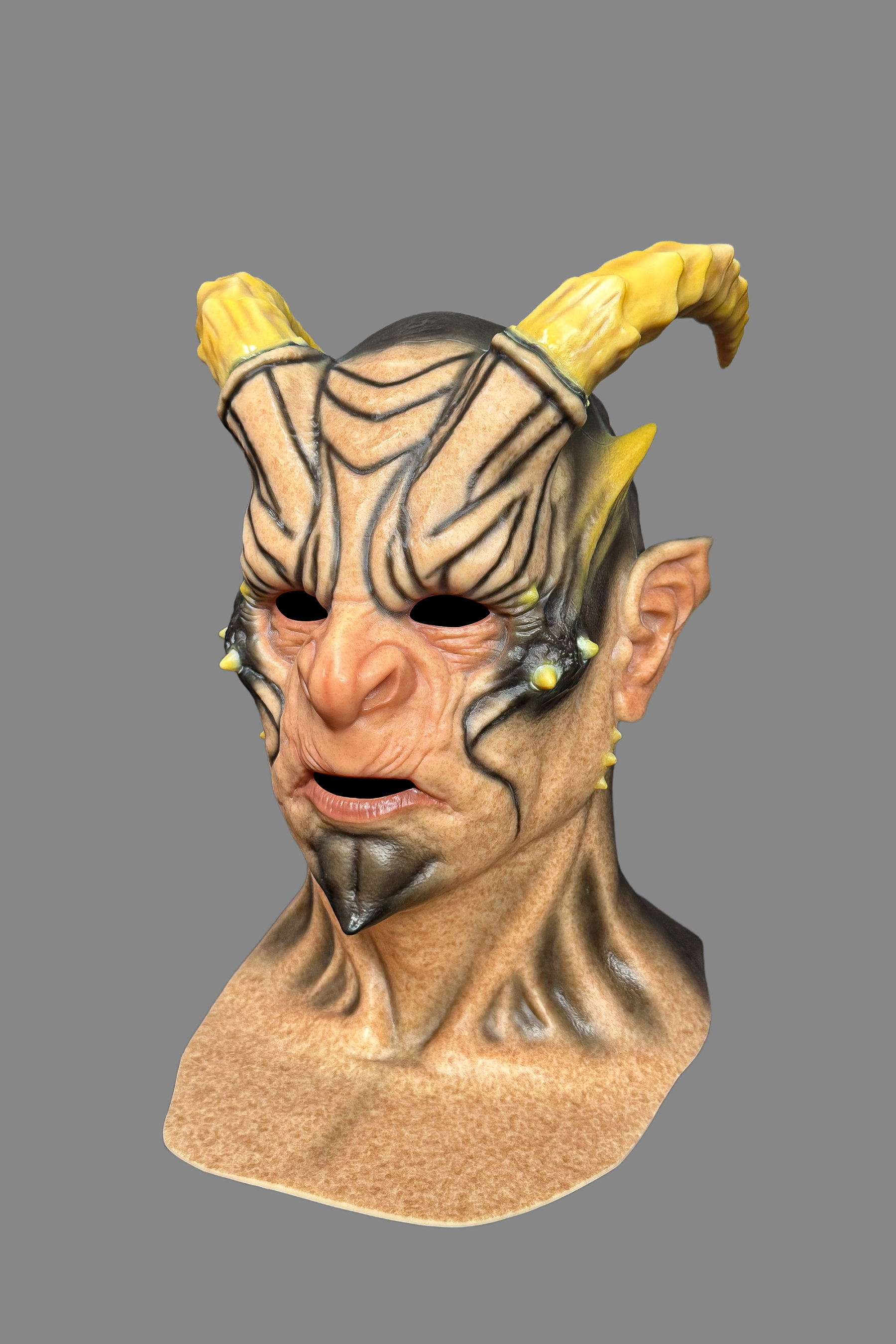 Premium devil demon silicone mask with yellow horns, black tribal markings, angry wrinkled face and open mouth, full front view on model.