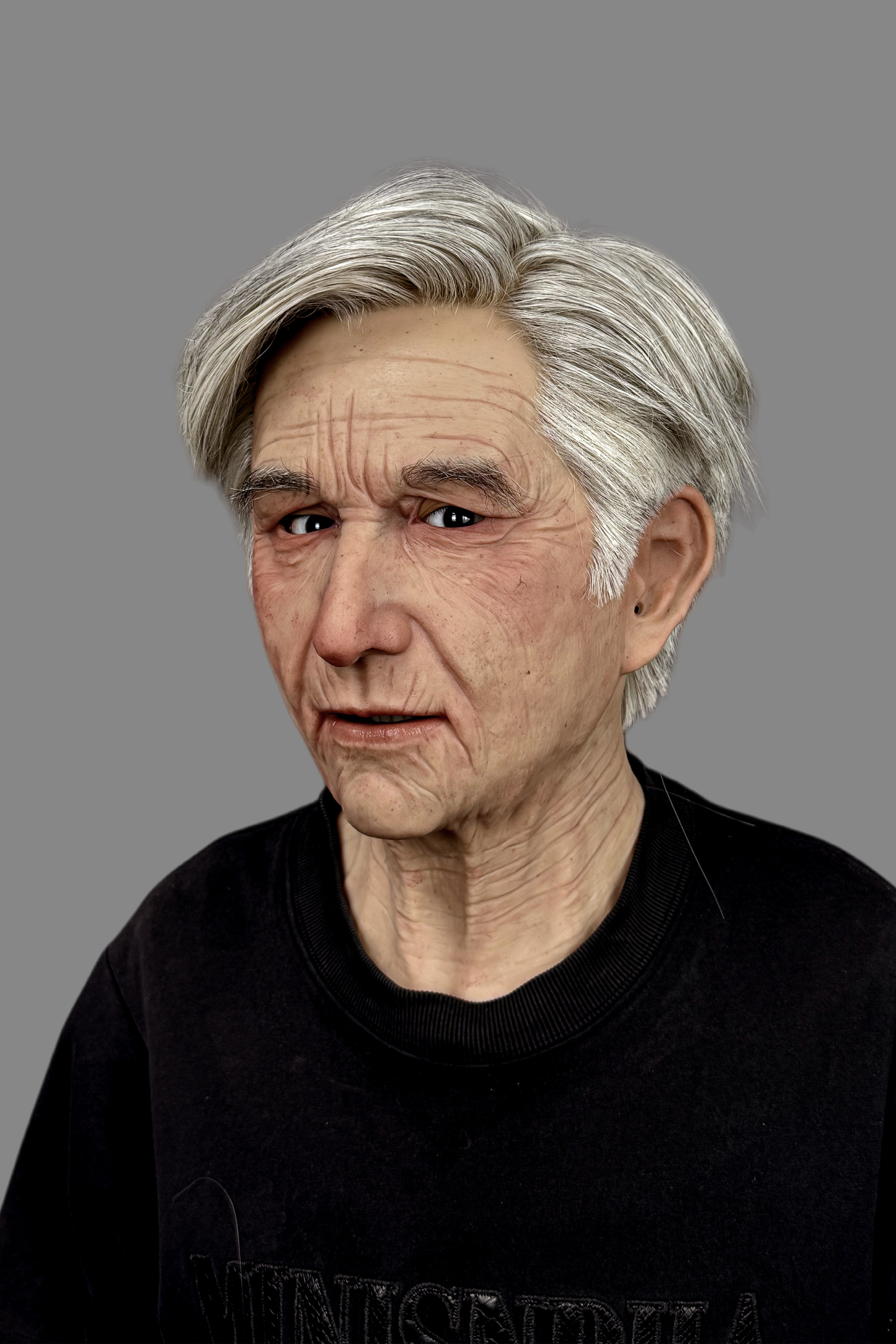 Ultra-realistic old man silicone mask featuring hand-punched gray hair and detailed aging skin, three-quarter angle.