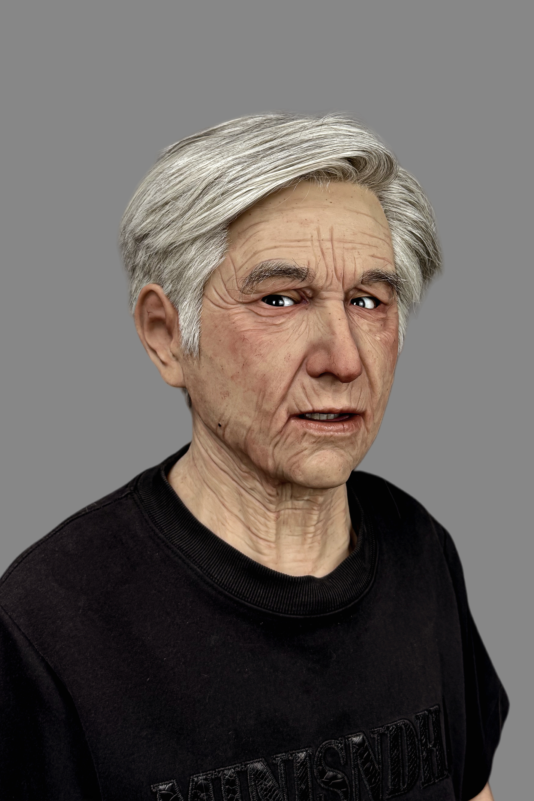 Professional elderly gentleman silicone disguise mask with realistic wrinkles, age spots, and implanted gray hair, side view.
