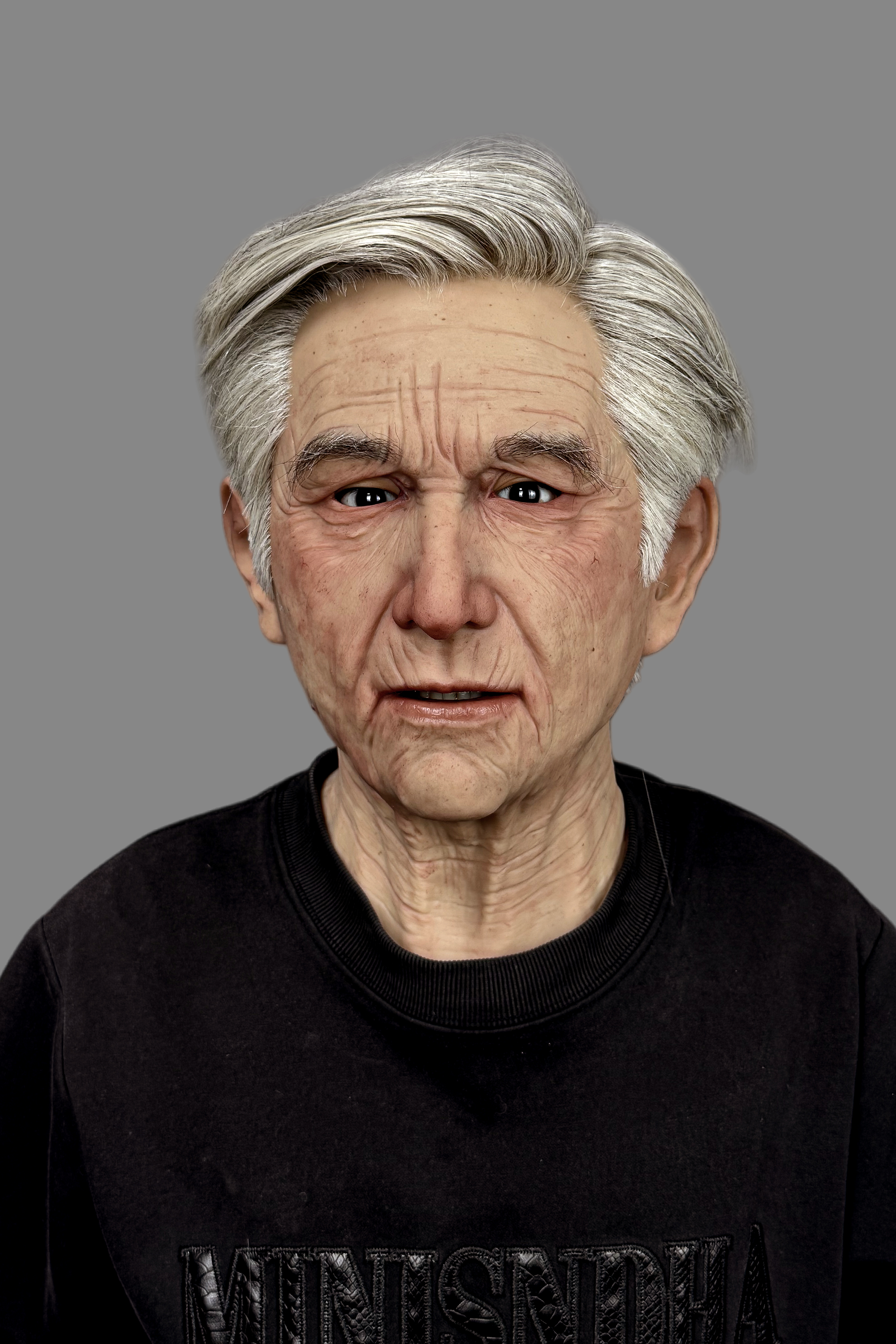 Hyper-realistic elderly Caucasian male silicone mask with gray hair, deep wrinkles, and lifelike skin texture, front view worn on model.