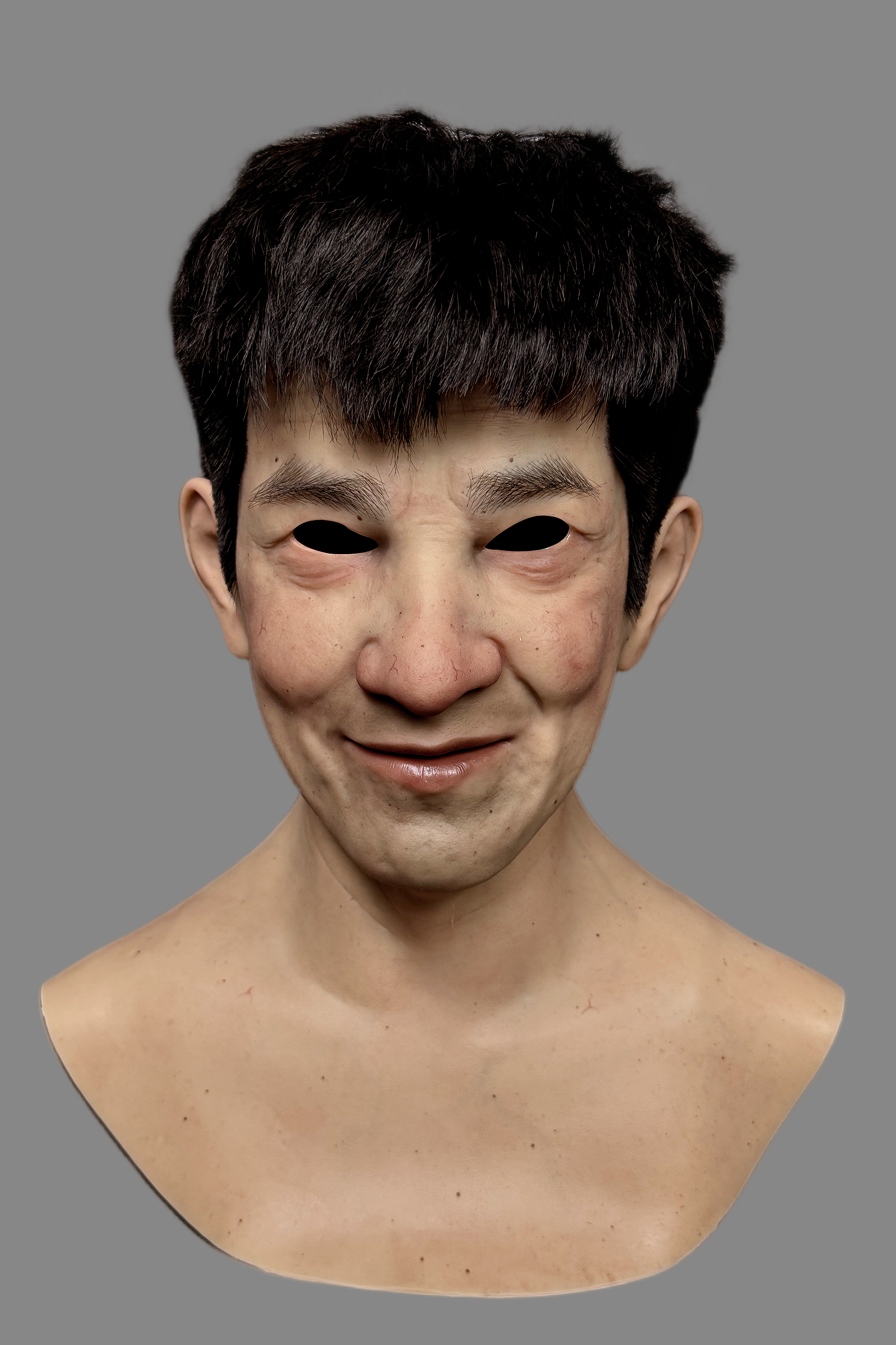 Hyper-realistic male full-face silicone mask worn on model, displaying exaggerated funny expression and detailed skin.
