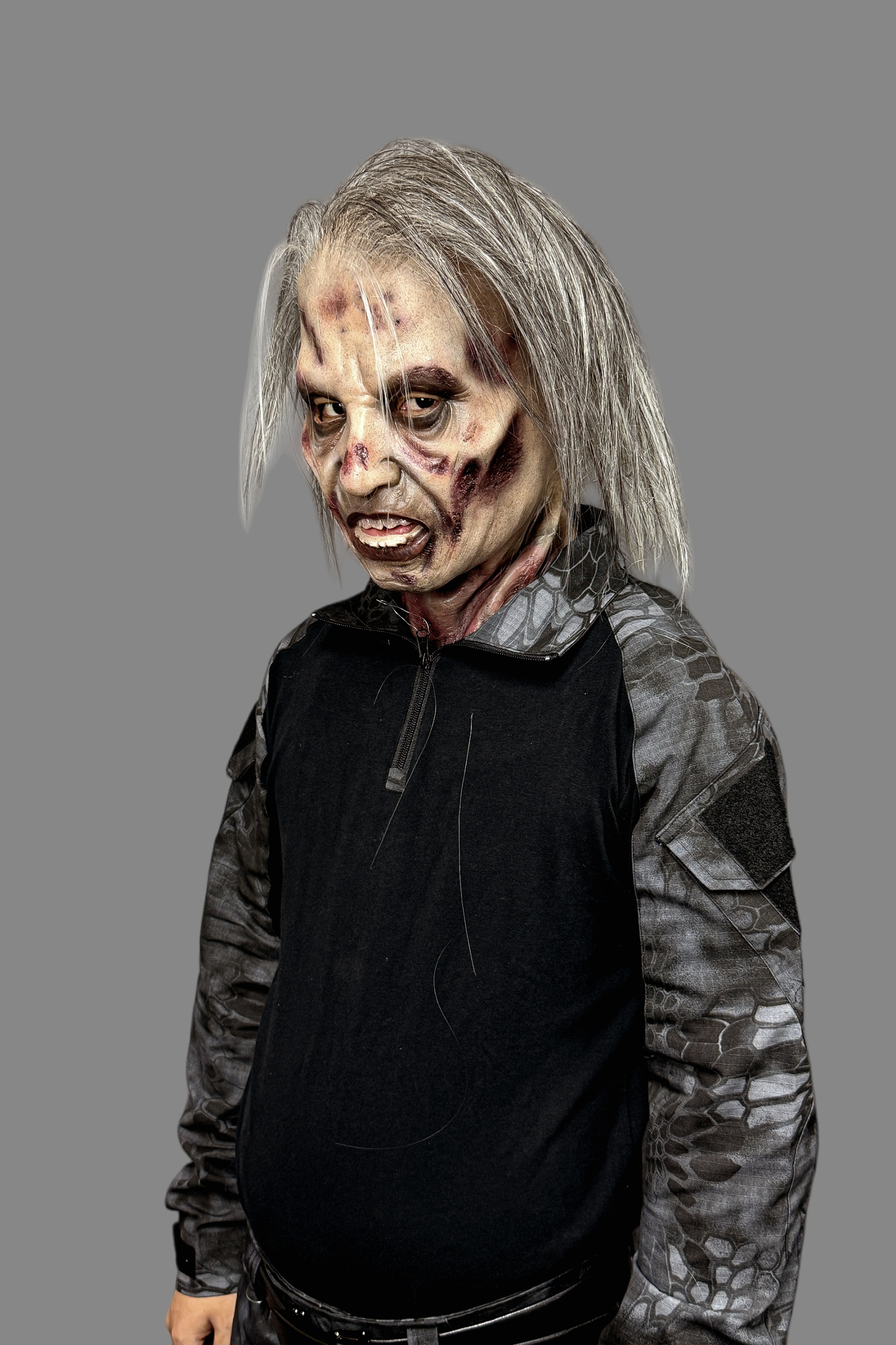 Professional hyper-realistic zombie old man mask with blood-stained neck blend, exposed teeth and sunken eyes, front detail.
Side profile in full tactical gear
