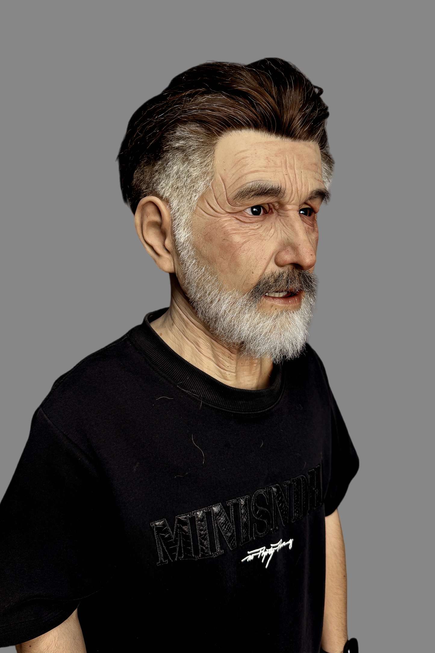 Lifelike aged male silicone disguise mask with retro slicked-back hairstyle, thick white beard and natural skin veins, angled view on model.