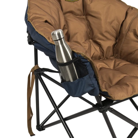 Travel bottle sitting in cup holder on side of chair.