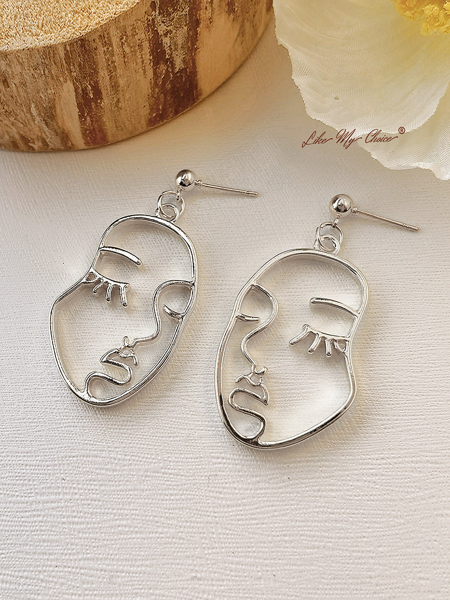 Pendientes colgantes modernos con rostro humano abstracto