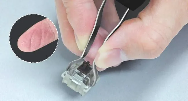 Traditional metal switch puller gripping a keyboard switch