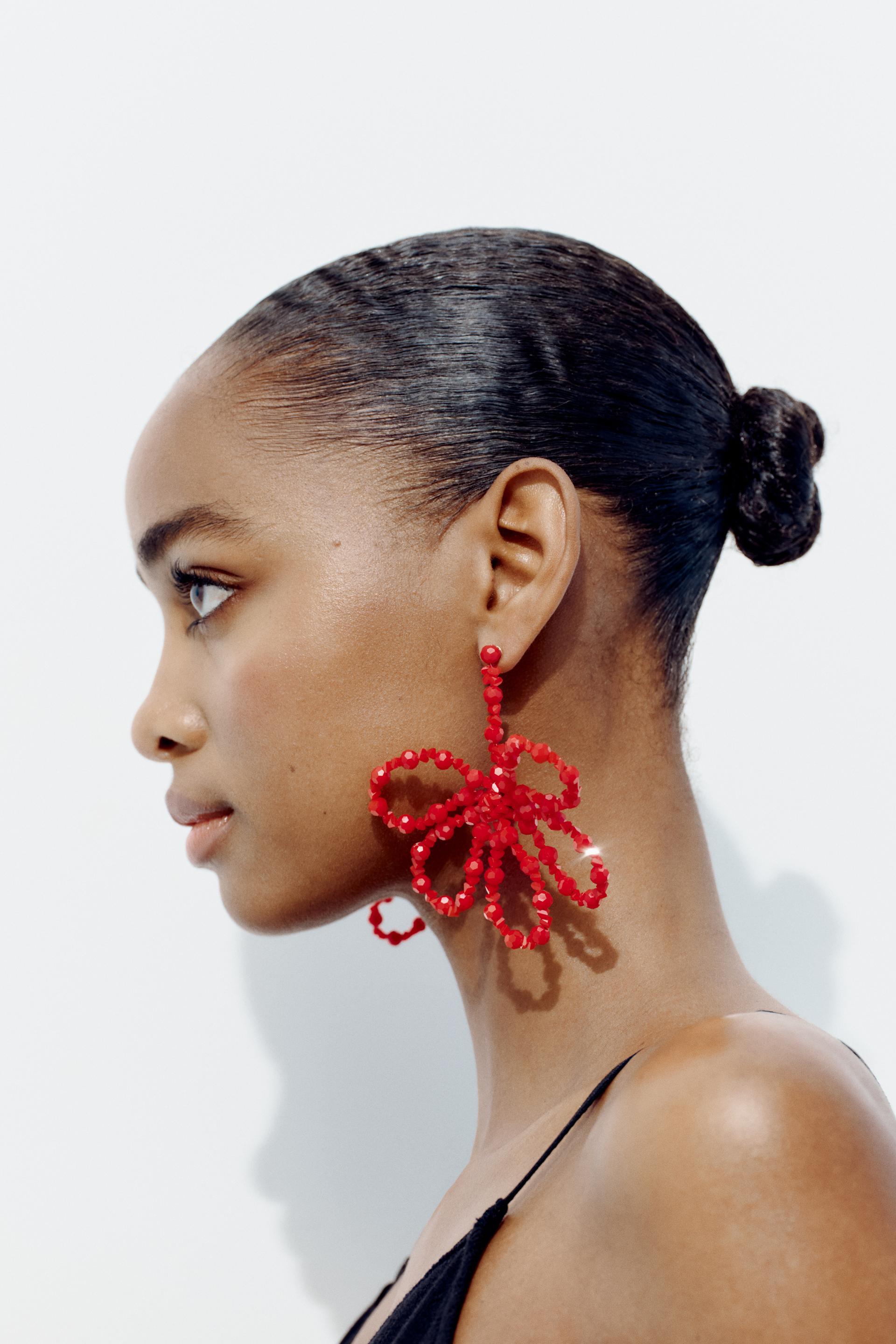Flower shaped metal drop earrings with colorful bead appliqu. Butterfly closure.