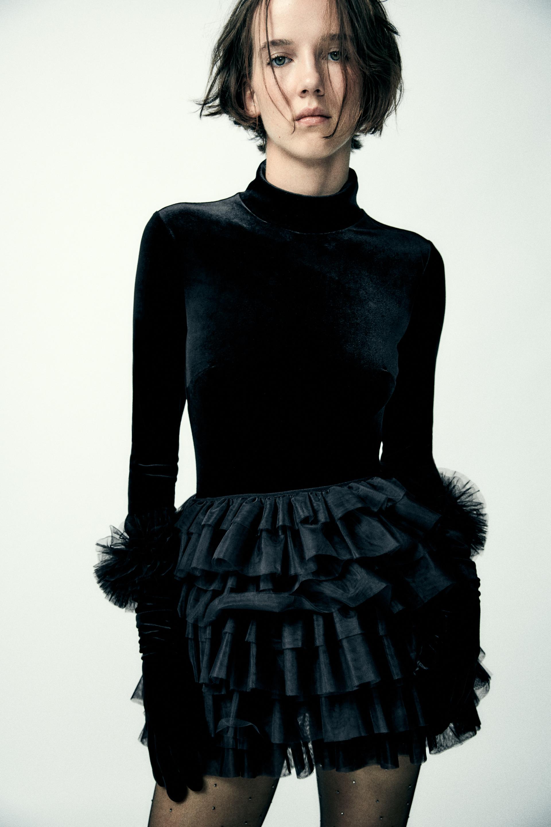 Mini skirt with a mid elastic waistband. Tulle ruffle details. Matching interior lining.