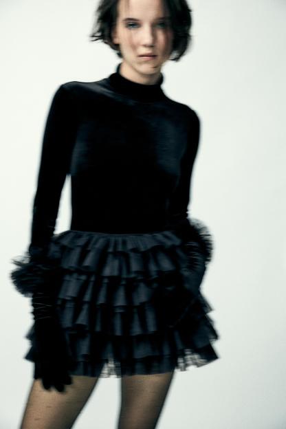 Mini skirt with a mid elastic waistband. Tulle ruffle details. Matching interior lining.