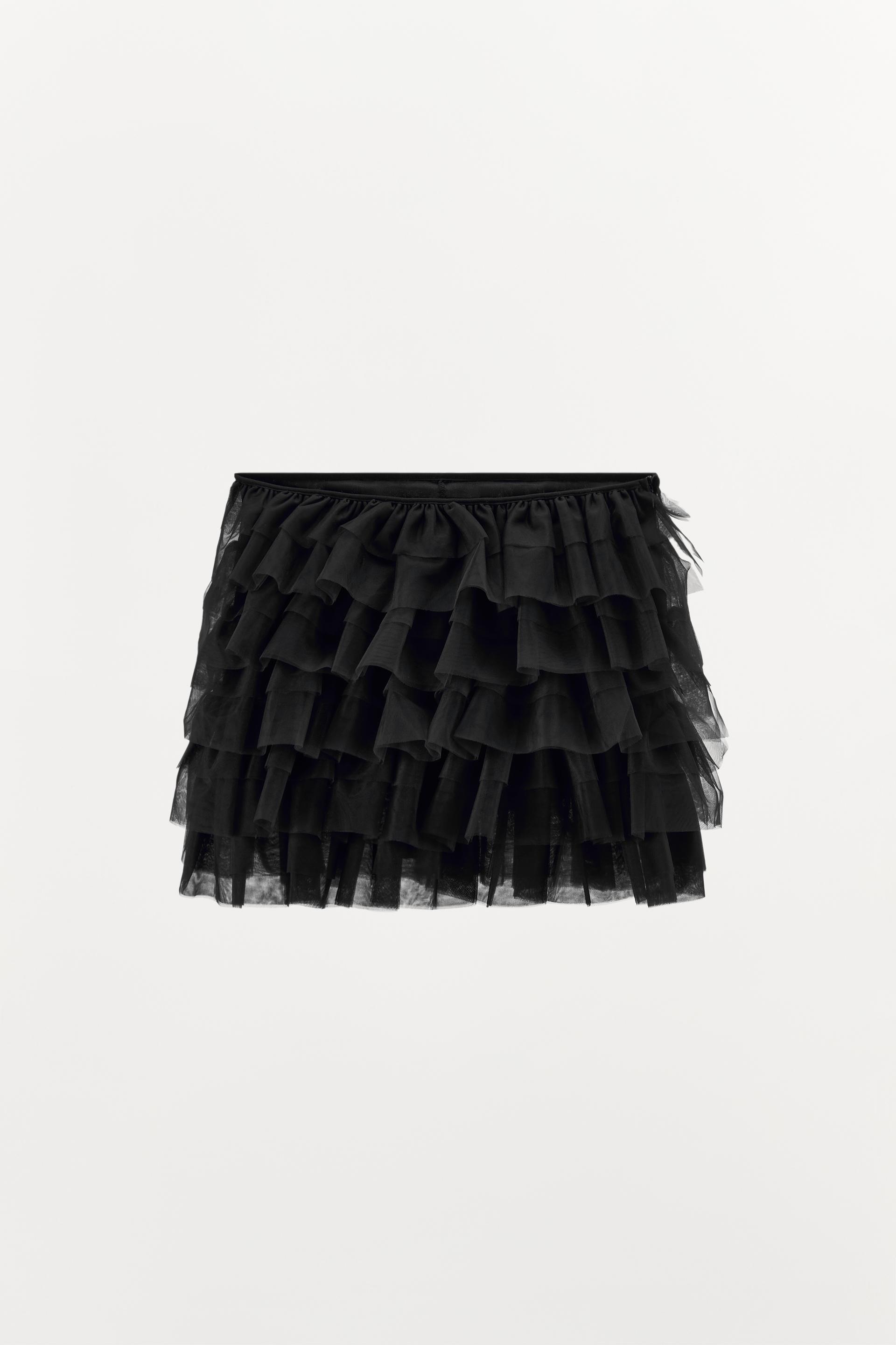 Mini skirt with a mid elastic waistband. Tulle ruffle details. Matching interior lining.
