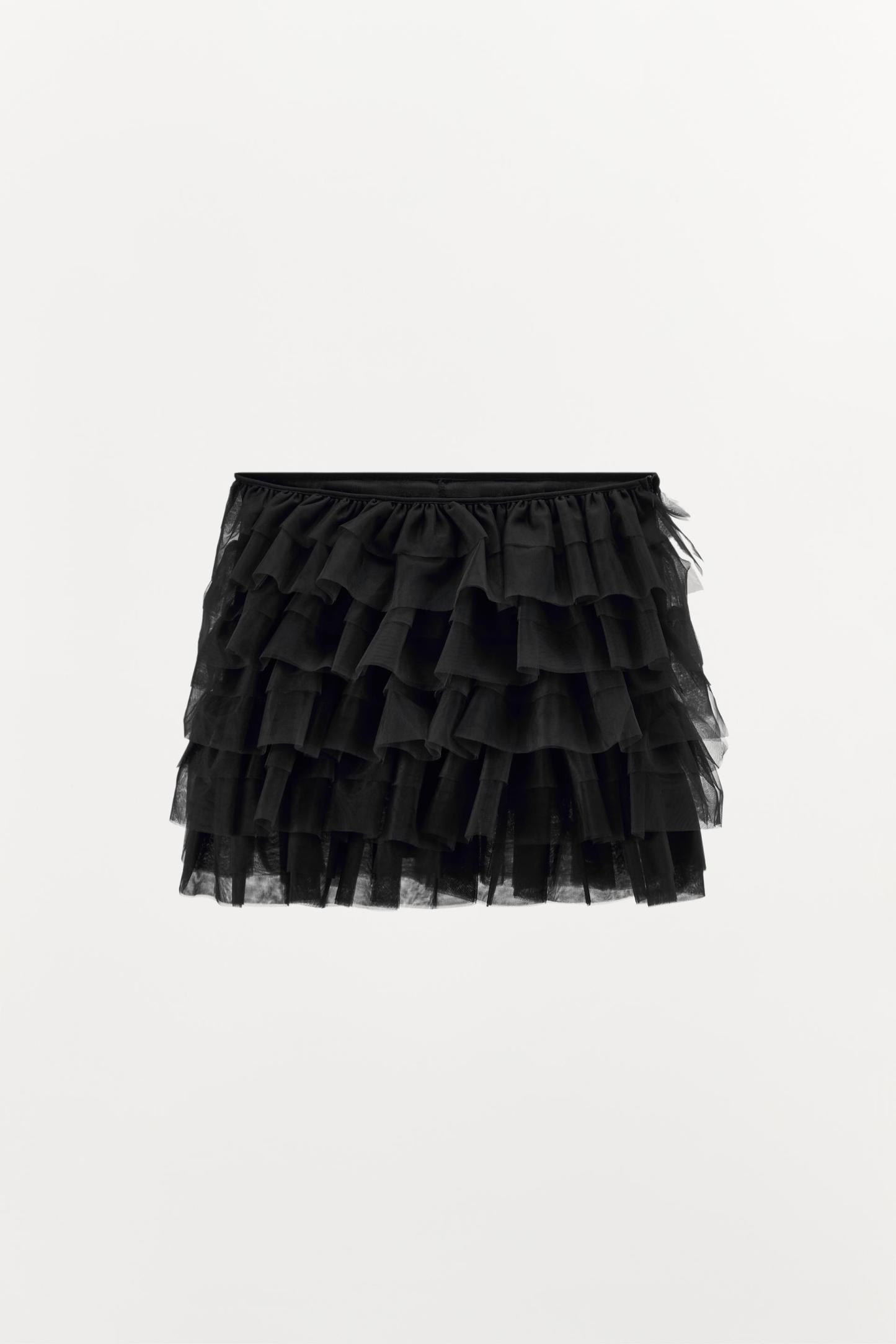 Mini skirt with a mid elastic waistband. Tulle ruffle details. Matching interior lining.