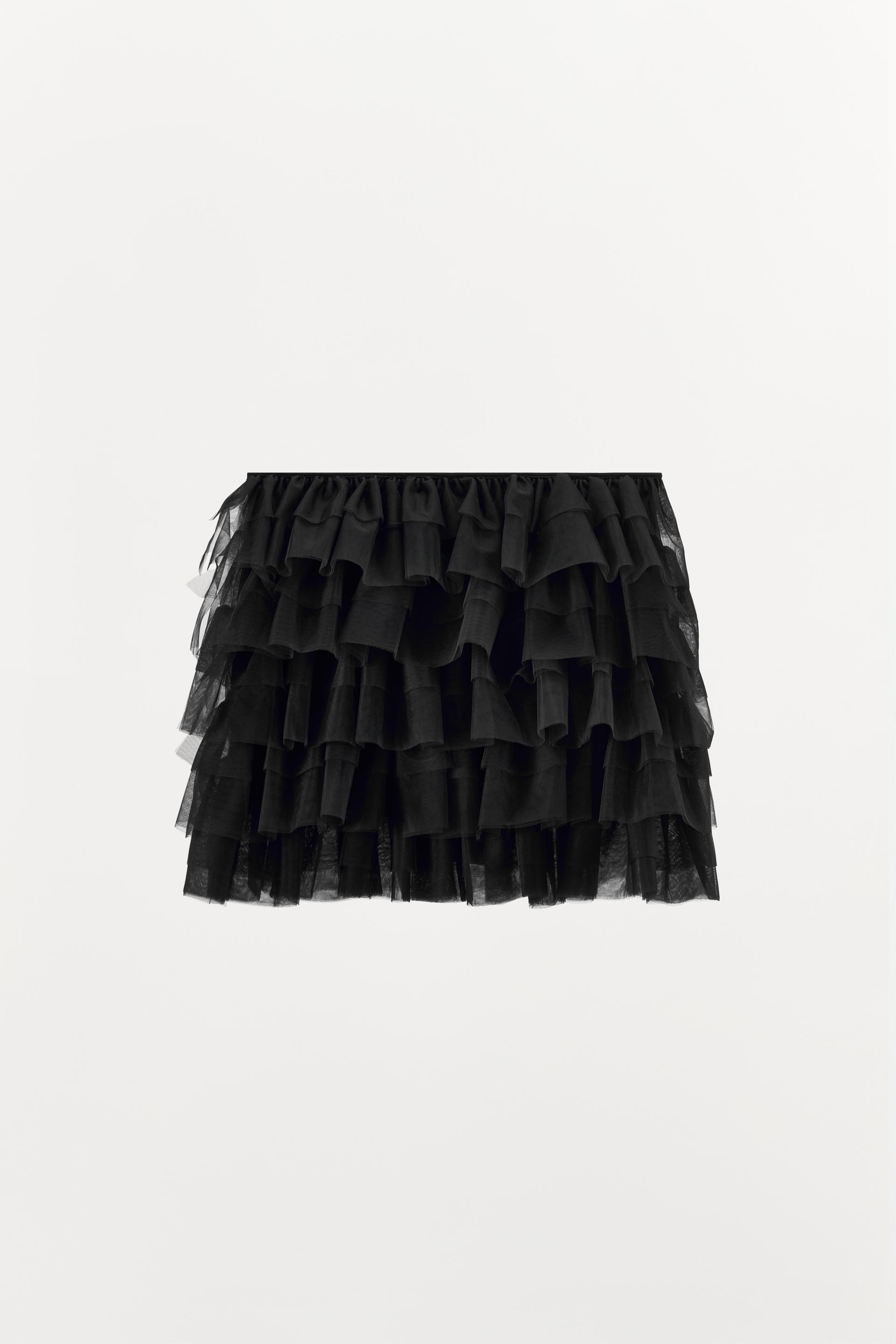 Mini skirt with a mid elastic waistband. Tulle ruffle details. Matching interior lining.