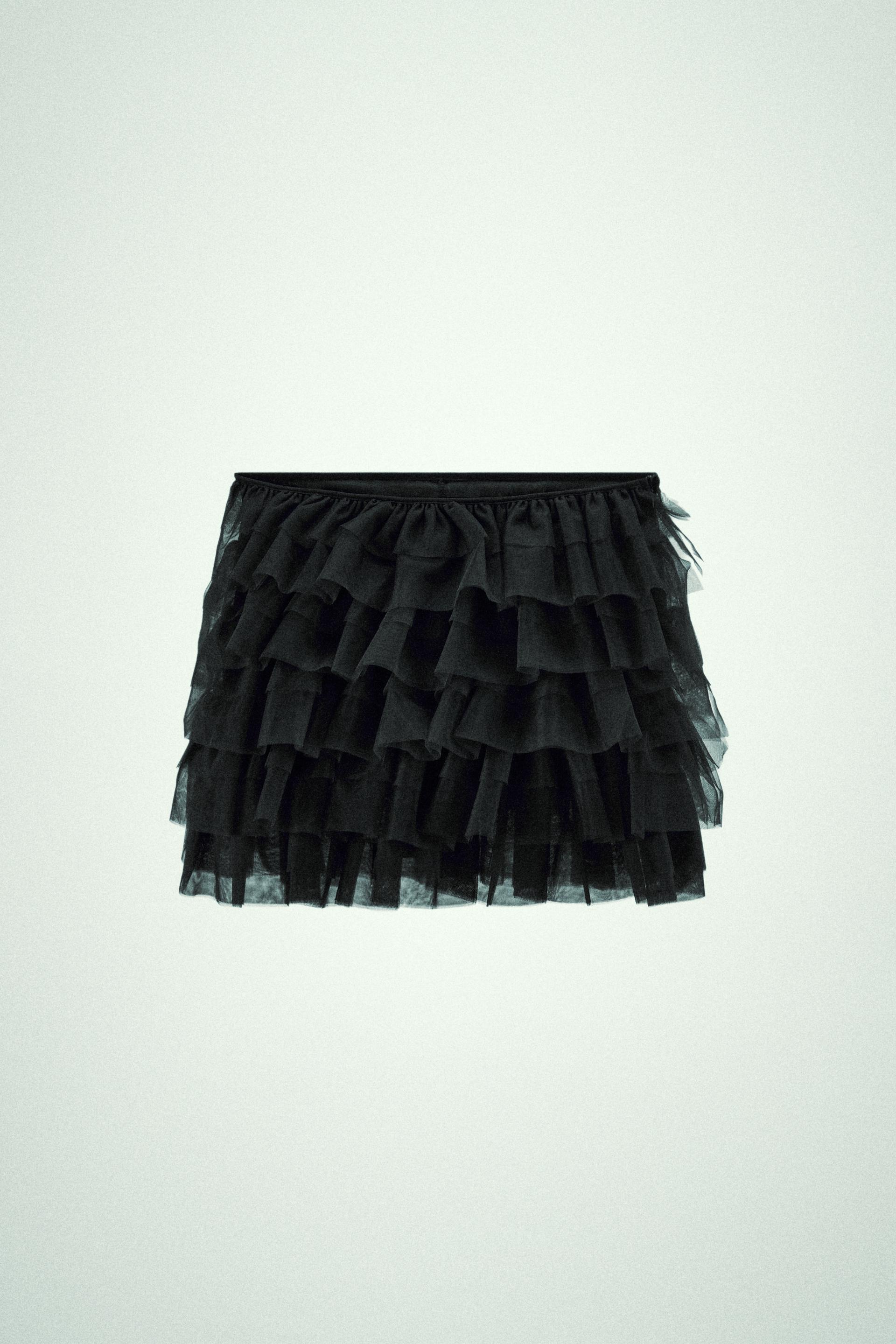 Mini skirt with a mid elastic waistband. Tulle ruffle details. Matching interior lining.