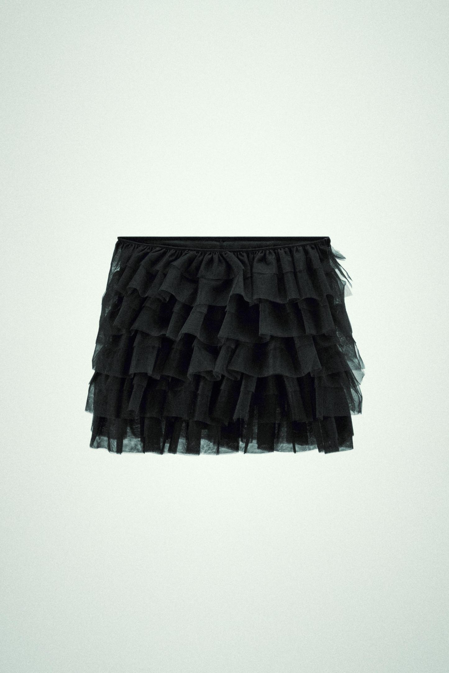 Mini skirt with a mid elastic waistband. Tulle ruffle details. Matching interior lining.
