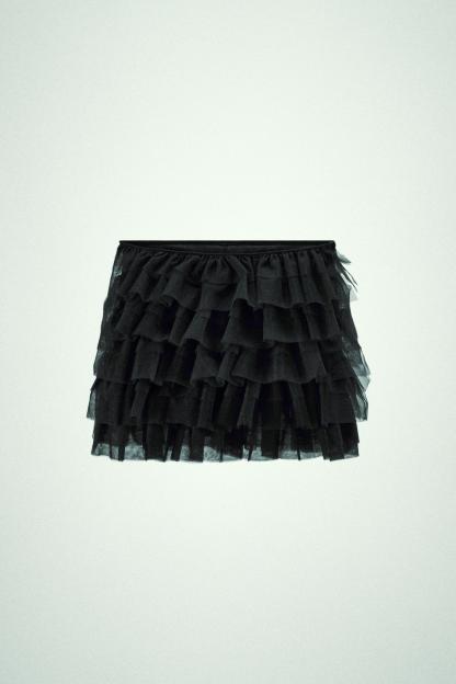 Mini skirt with a mid elastic waistband. Tulle ruffle details. Matching interior lining.