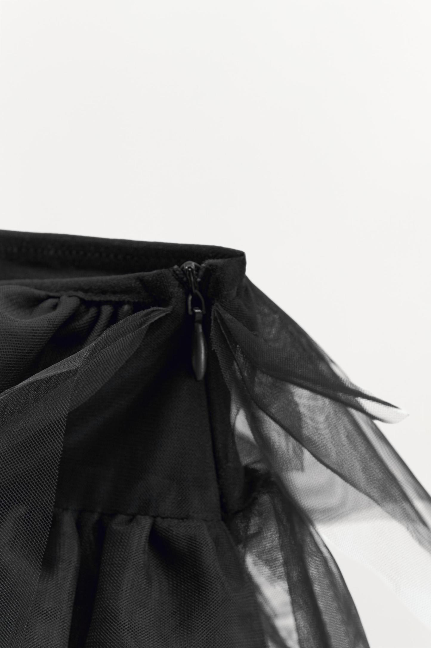 Mini skirt with a mid elastic waistband. Tulle ruffle details. Matching interior lining.