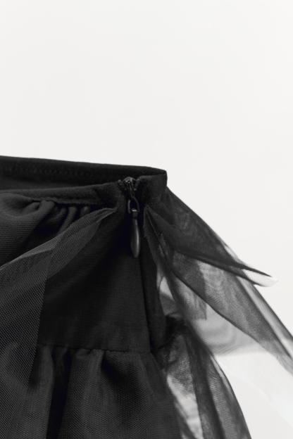 Mini skirt with a mid elastic waistband. Tulle ruffle details. Matching interior lining.