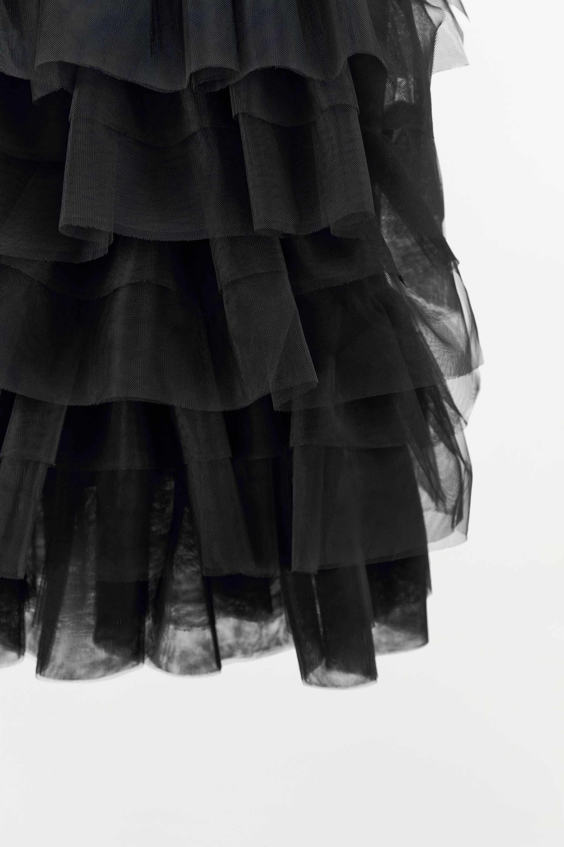 Mini skirt with a mid elastic waistband. Tulle ruffle details. Matching interior lining.