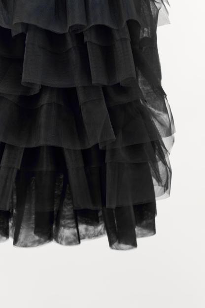 Mini skirt with a mid elastic waistband. Tulle ruffle details. Matching interior lining.