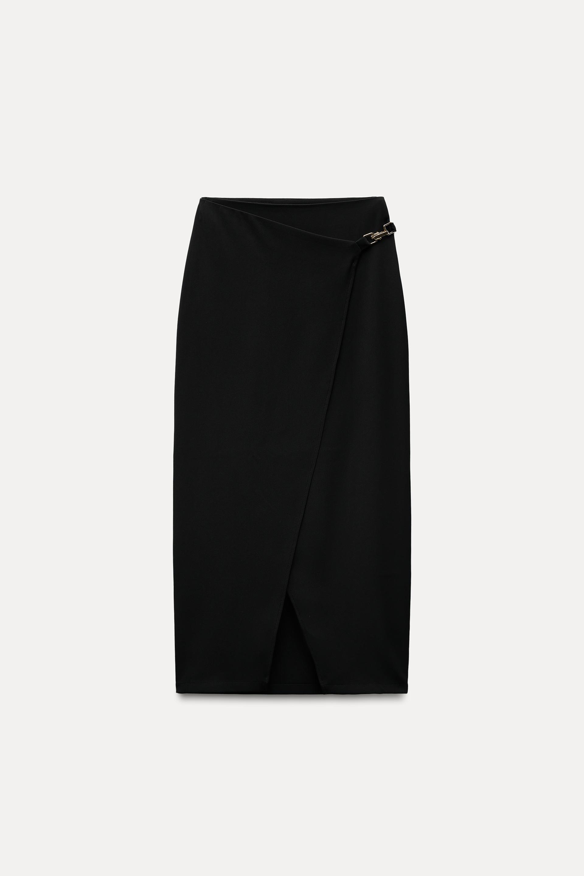 High waisted skirt with front slit. Wrap closure with hidden interior button and golden clip appliqu.