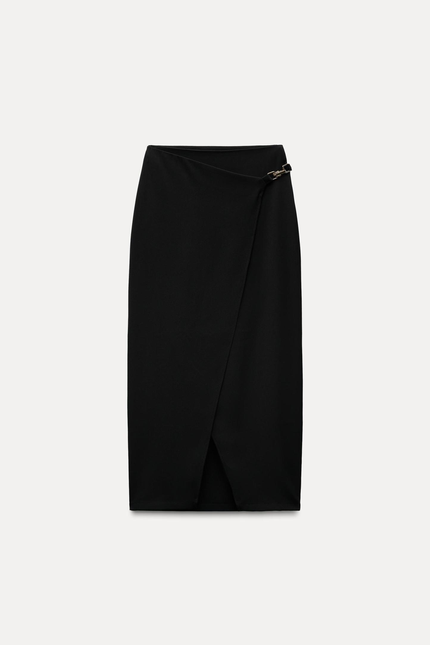 High waisted skirt with front slit. Wrap closure with hidden interior button and golden clip appliqu.