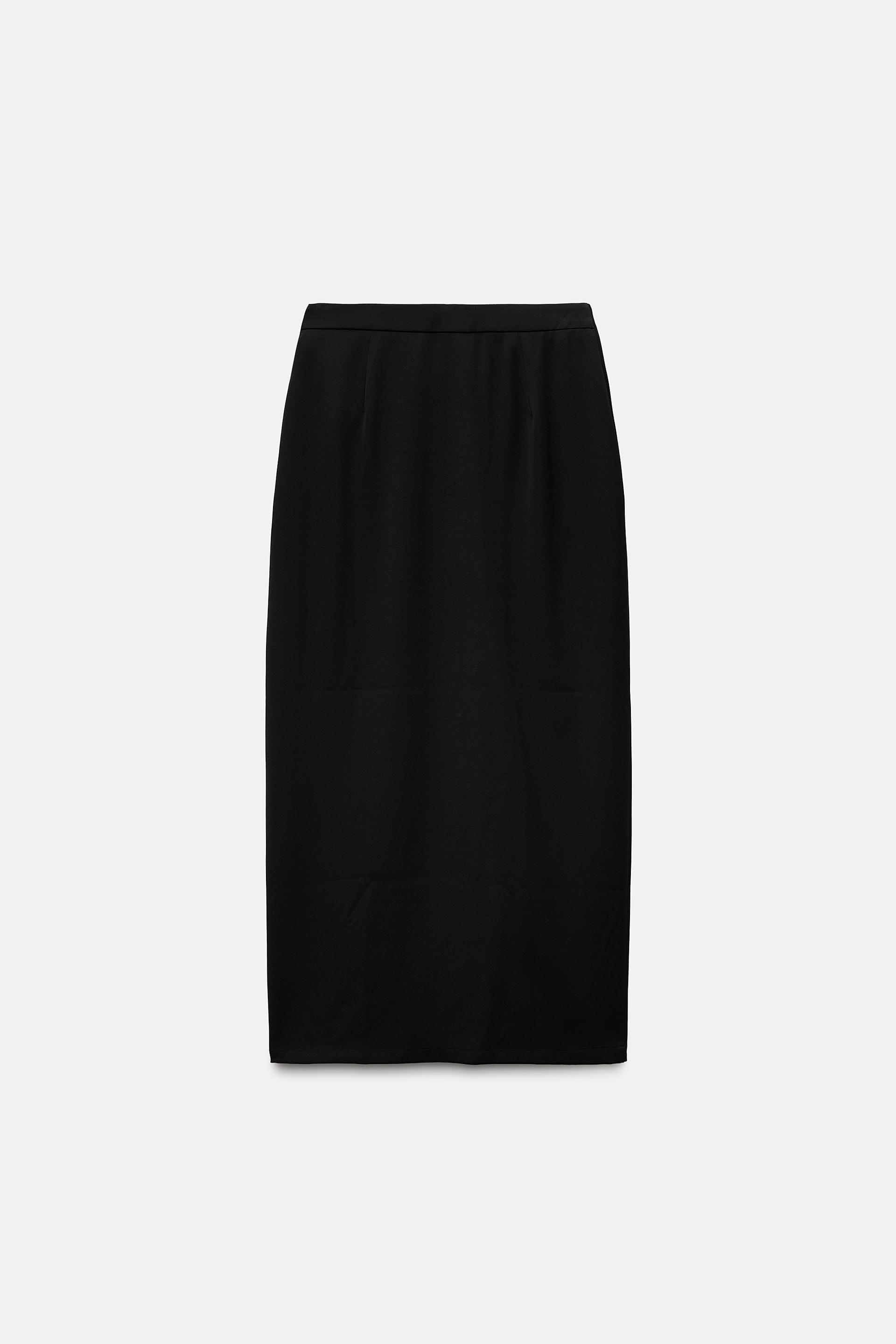 High waisted skirt with front slit. Wrap closure with hidden interior button and golden clip appliqu.