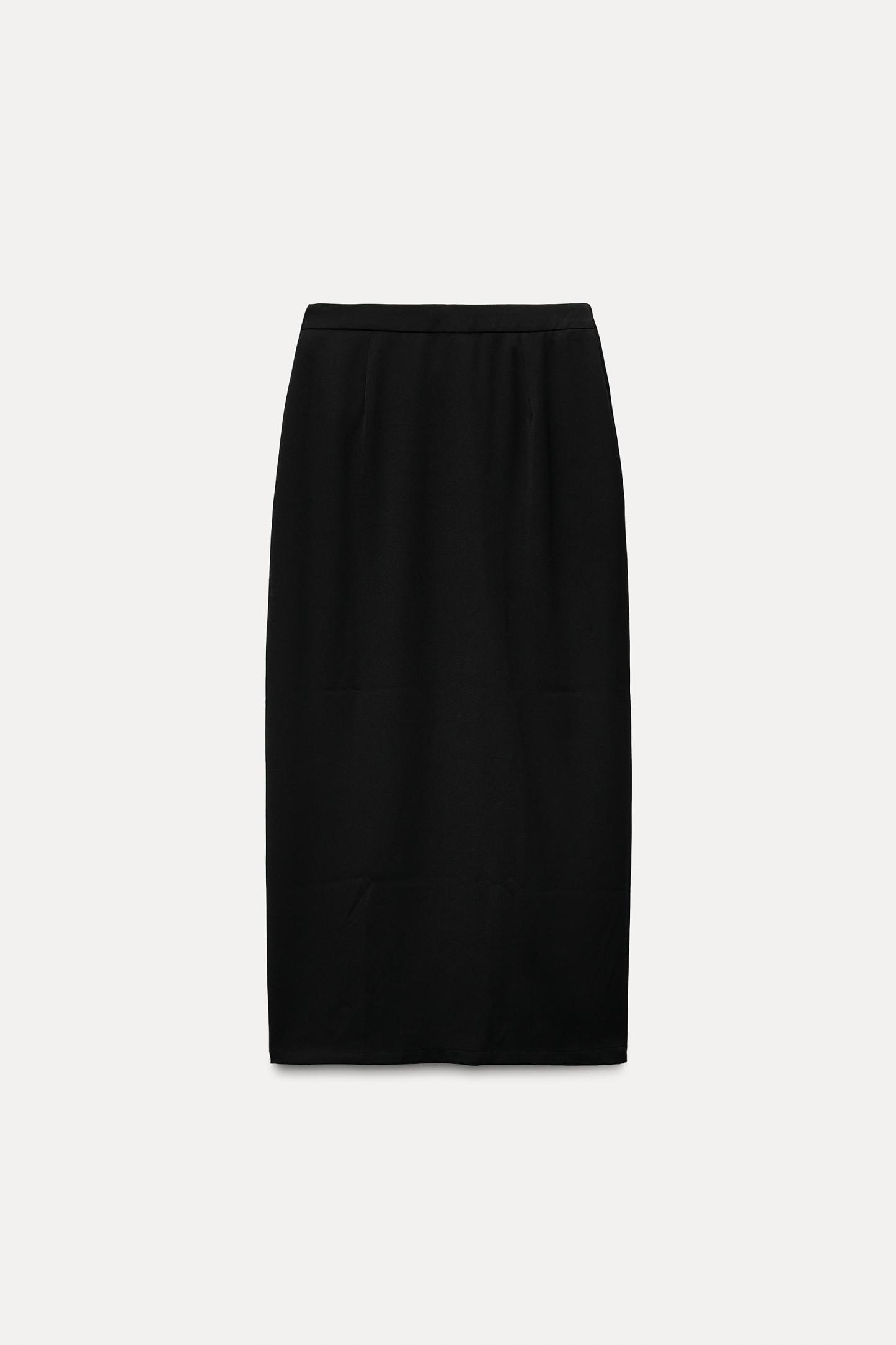 High waisted skirt with front slit. Wrap closure with hidden interior button and golden clip appliqu.