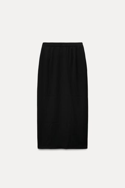 High waisted skirt with front slit. Wrap closure with hidden interior button and golden clip appliqu.