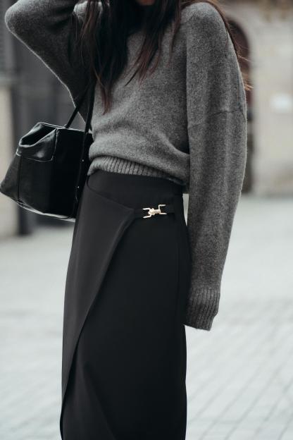 High waisted skirt with front slit. Wrap closure with hidden interior button and golden clip appliqu.