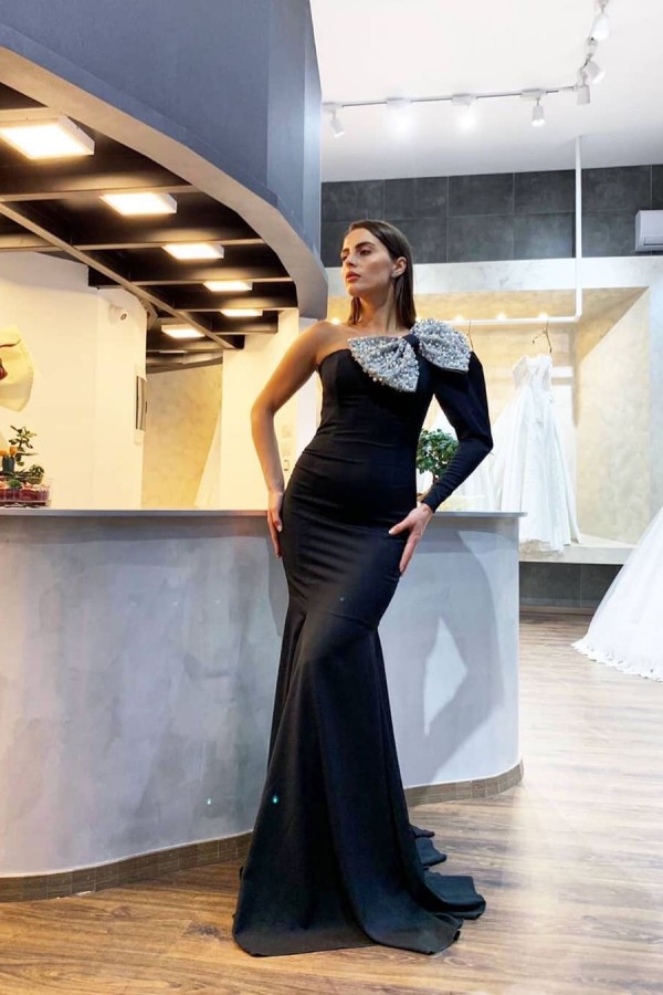 One-shoulder black sequined evening dress with a bow detail