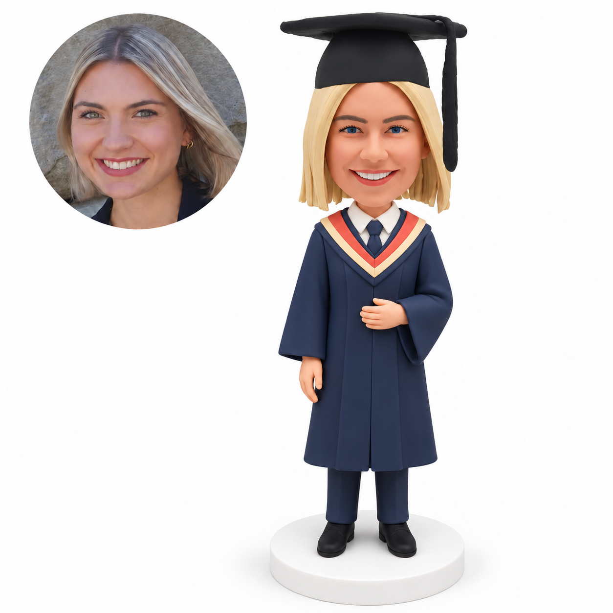 Custom polymer-clay female graduate with her empty left hand resting across the gown front and right arm down, wearing a navy gown with coral hood and mortarboard on a plain round base, with matching real portrait